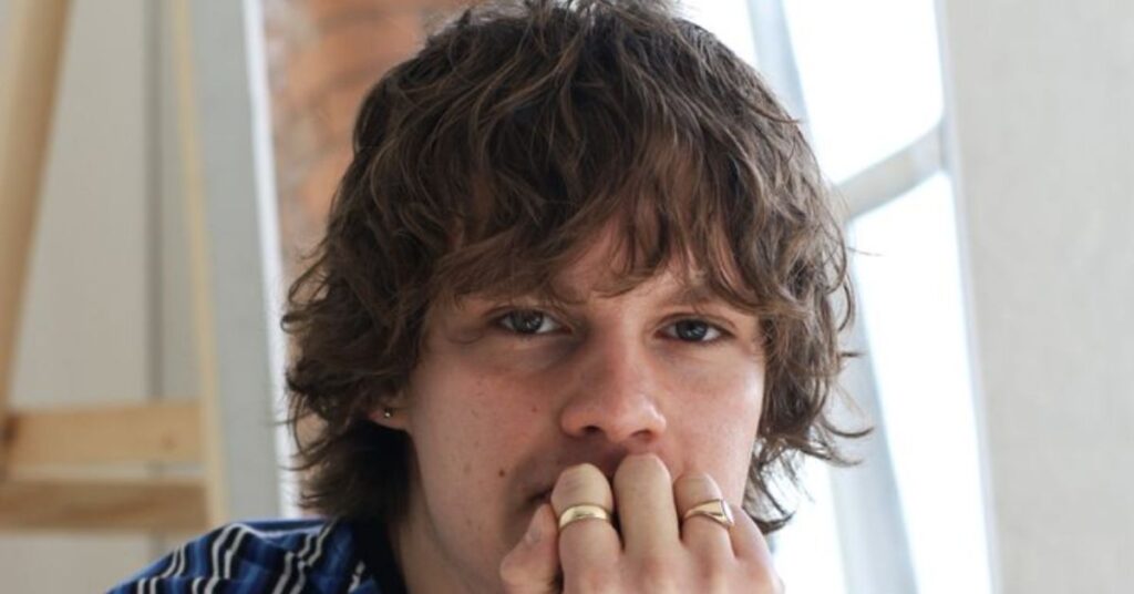 Alt Text: 90s Britpop mod cut with messy layers and a longer fringe, representing one of the best mod haircuts for men inspired by Oasis.