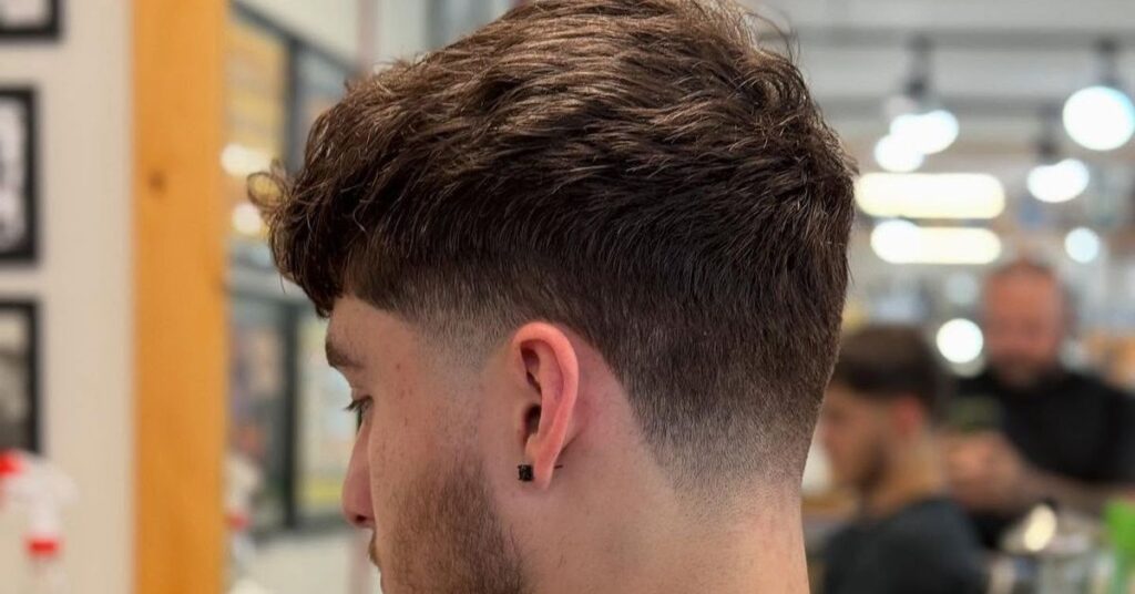 Bold burst fade mohawk for men with textured layered height and clean side fades.