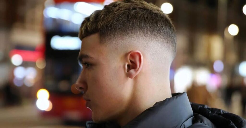 Clean mid fade with messy textured top and short layered hair for men