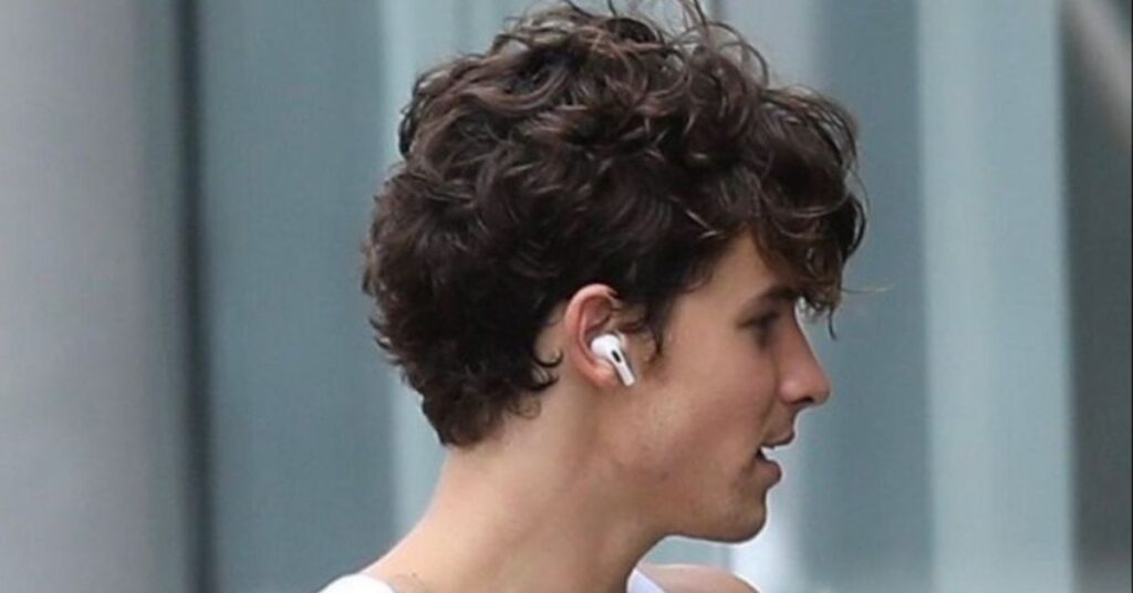 Curly mod cut with natural volume and a heavy fringe.