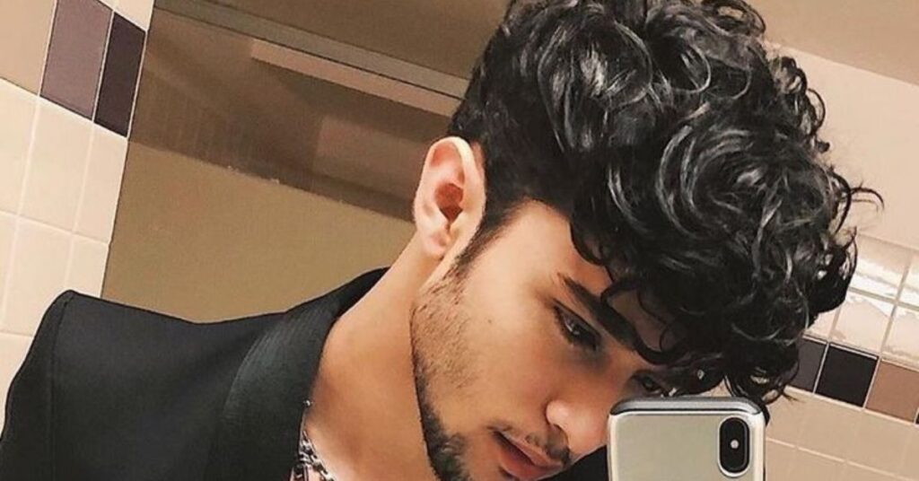 Messy curly fringe for men with layered curls and a textured voluminous top.