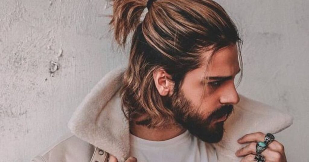 Long hair man bun slick back hairstyle for men with tied-up top and sleek sides