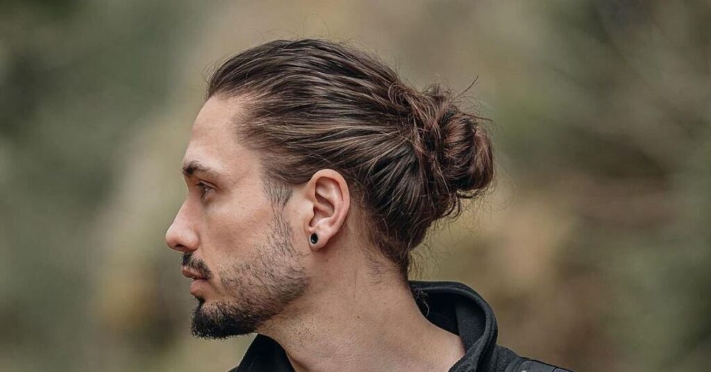 Messy top knot hair mens with partial bun and loose textured strands