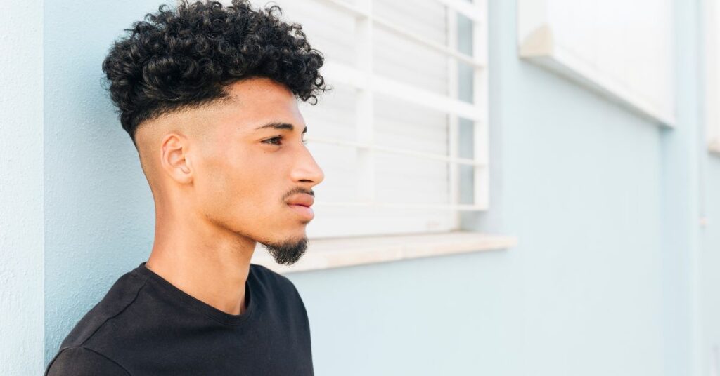 Modern textured slick back with a matte finish and medium taper fade for men