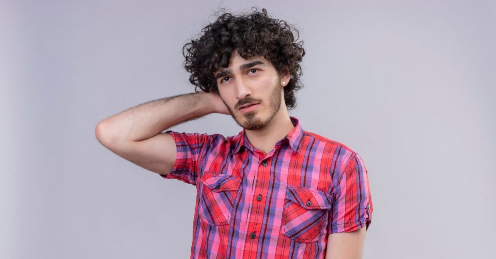 Curly shag haircut for men featuring defined natural curls, extreme layered volume, and a curly fringe for a wild textured look.
