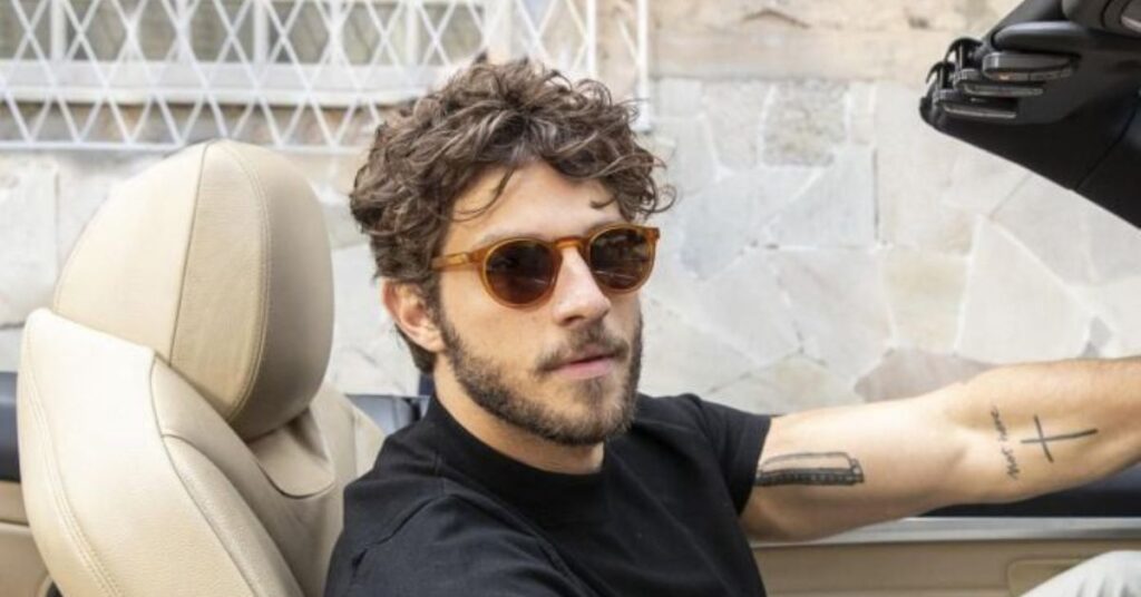 Mod quiff haircut with a voluminous swept-up front and short sides.