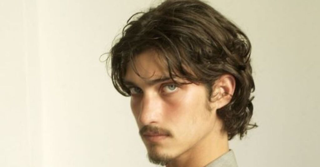 Modern textured wolf cut for men with choppy layers and a tapered back