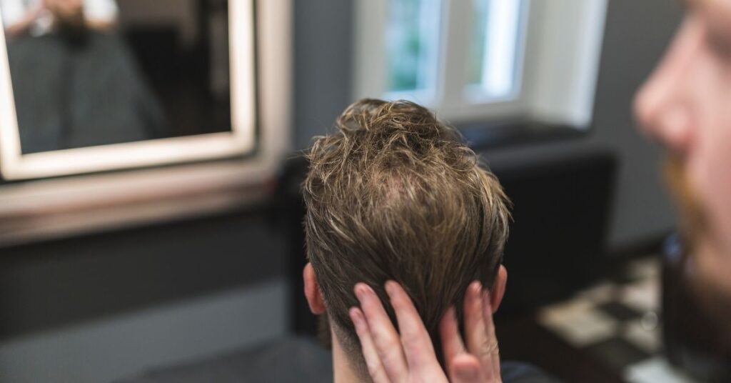 Thin hair volumizing slick back hairstyle for men with added texture and lift