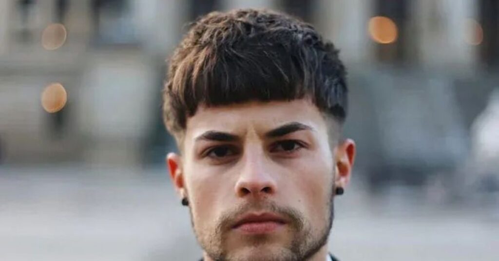 Stylized modern bowl cut for men with a straight-across fringe and sharp finish.