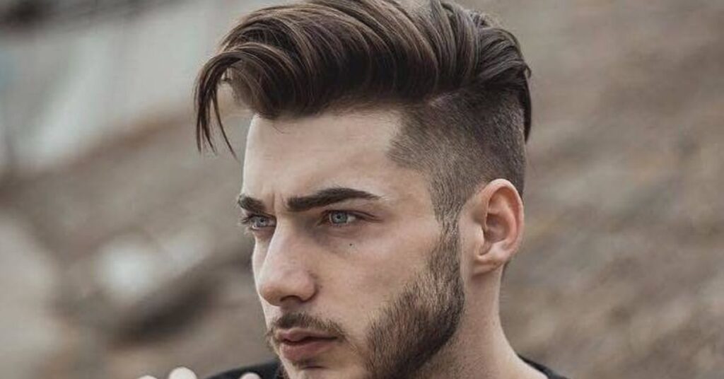 Voluminous swept-back hairstyle for men with textured layers and a clean taper.