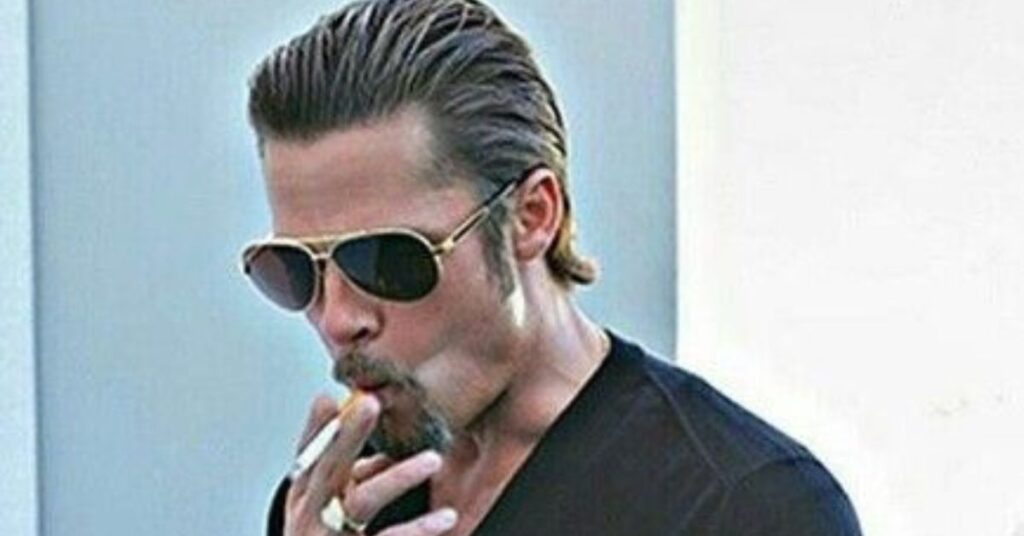 Long slick back hairstyle for men with hair combed straight back behind the ears.