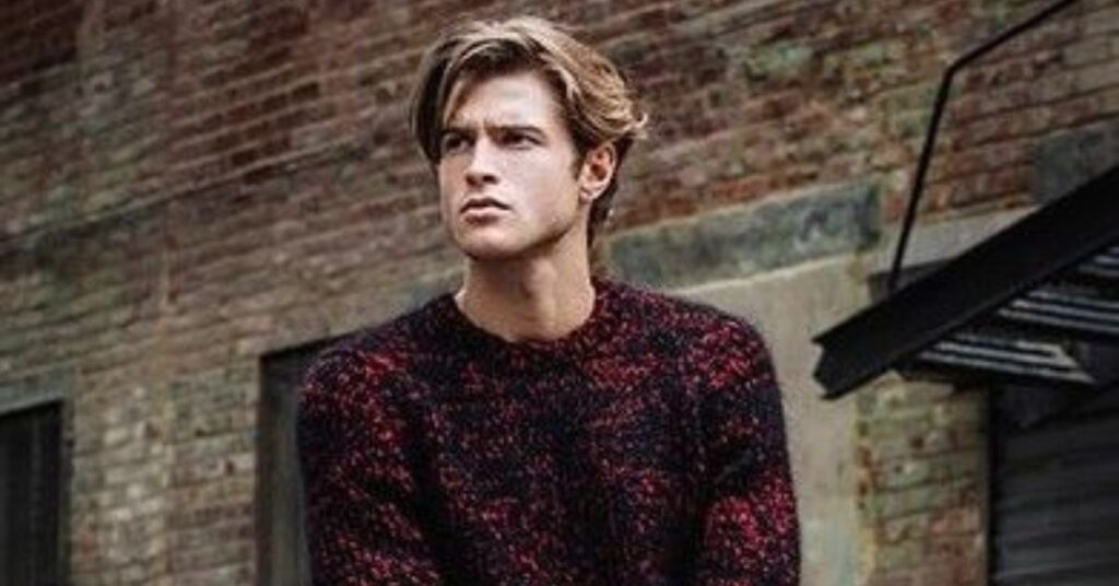 Side-swept long hairstyle for men with deep parting and layered texture.