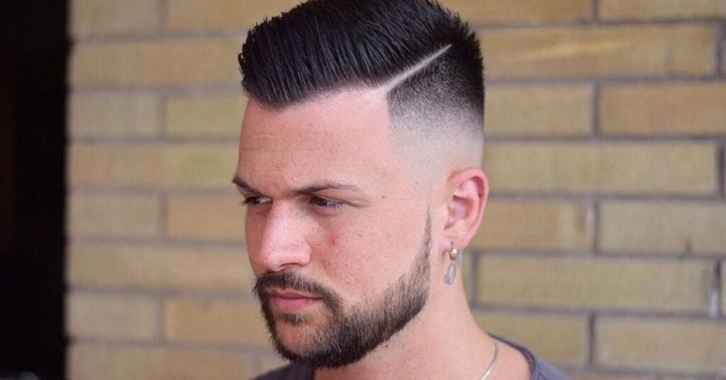 Edgy comb over mohawk for men with a sharp side-swept ridge and tapered sides.