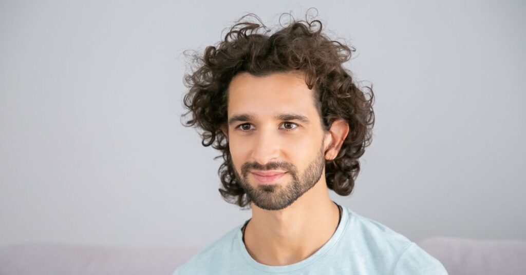 Voluminous curly shag cut with face-framing layers and crown volume.