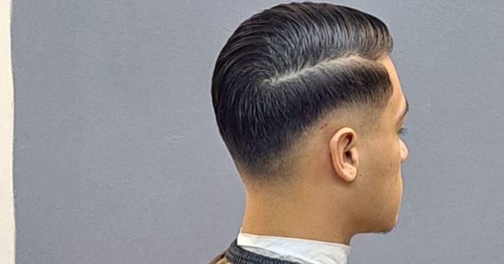 Symmetrical drop fade comb over for men following the natural head shape.