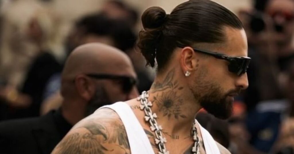 Long hair man bun with a high skin fade for summer.