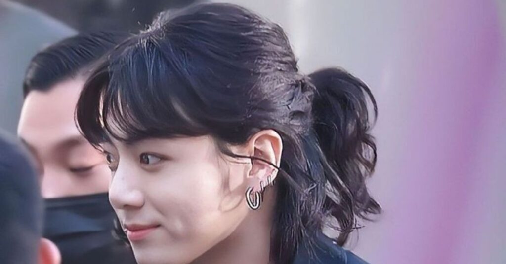 Sleek K-Pop idol style ponytail Korean hairstyle cut with loose strands.